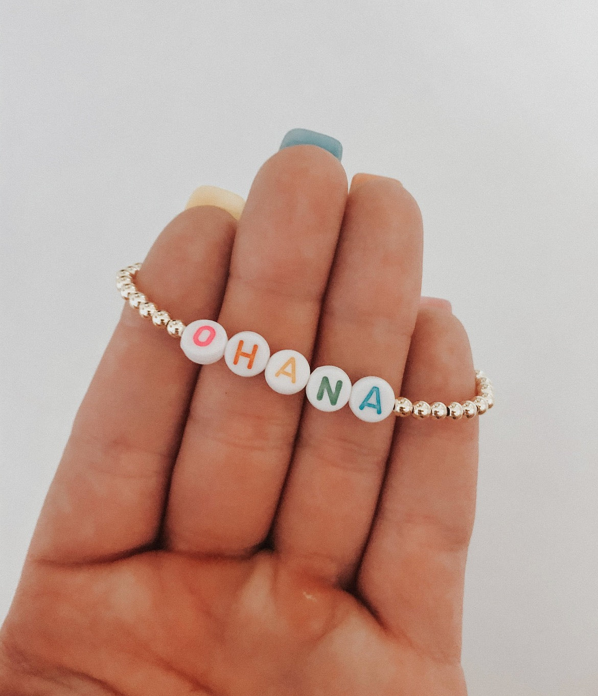 these bracelets are small gold beads with white beads that have different color letters that are able to spell out whatever you decide.