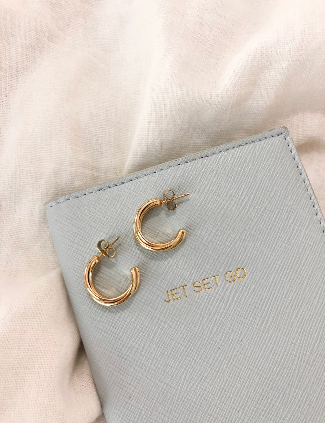 These earrings are two pieces of thin gold that are twisted and bound together. The hoop is quite small and does not hang very far below the ear lobe.