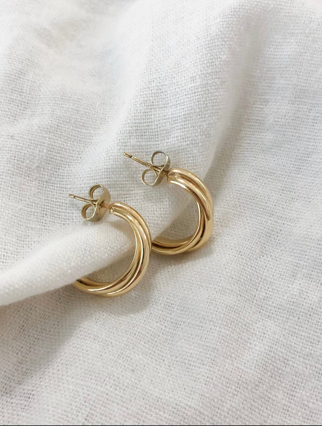 These earrings are two pieces of thin gold that are twisted and bound together. The hoop is quite small and does not hang very far below the ear lobe.