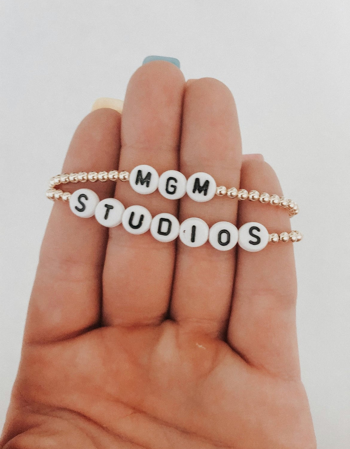 these bracelets are small gold beads with white and black letter beads that are able to spell out whatever you decide.