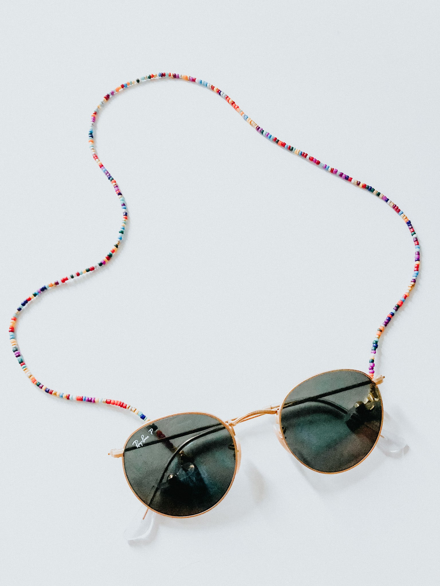 This sunglass chain is made of very small beads and is a very thin chain. It is many different colors in no pattern or order.
