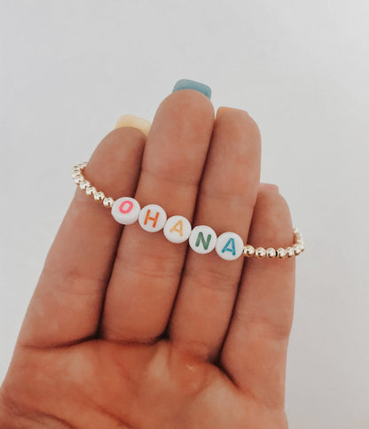 these bracelets are small gold beads with white beads that have different color letters that are able to spell out whatever you decide. 