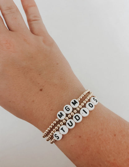 these bracelets are small gold beads with white and black letter beads that are able to spell out whatever you decide. 