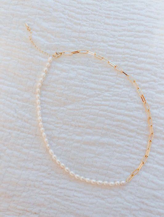 this necklace is split and has half of one design and half of another. On one side of it, it is a small thin gold linked "paper clip" style. On the other side it is white pearls. The clasp has multiple options for a looser fit or a tighter fit.